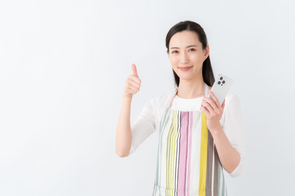 女性がスマホを持ってGoodをしてる