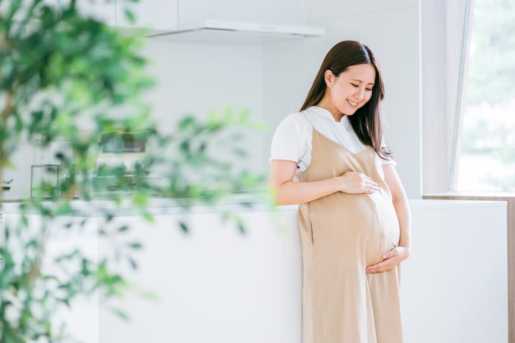 キッチンの前に立つ妊婦
